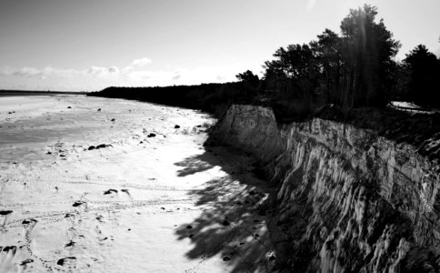 Grayscale Photo Of Mountain Cliff Near Ocean photo