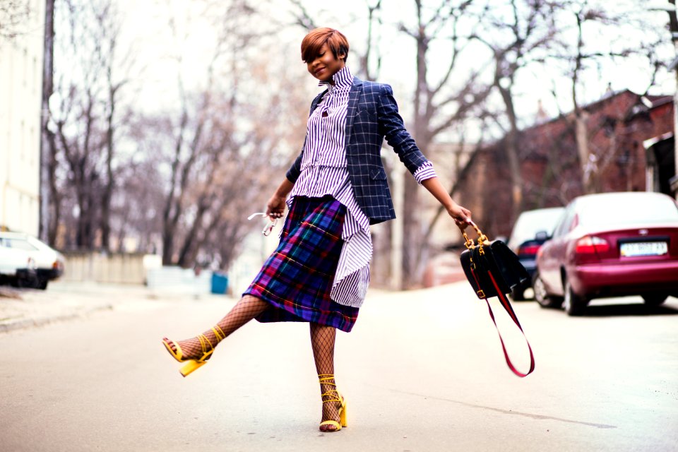 Woman In Purple Top And Plaid Skirt Near Car