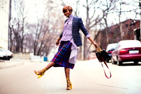 Woman In Purple Top And Plaid Skirt Near Car