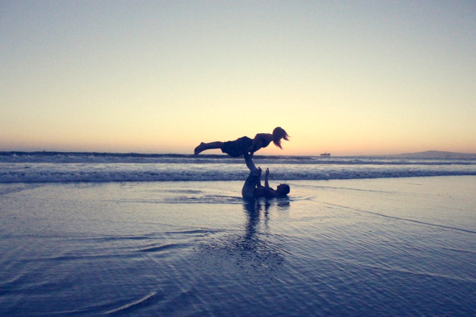Landscape Photography Of Man Lifting Woman By His Foot On Seashore