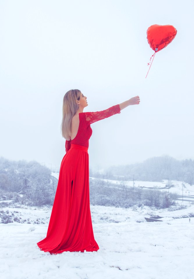 Woman In Red Floral Lace Long-sleeved Dress Standing With Red Heart Balloon