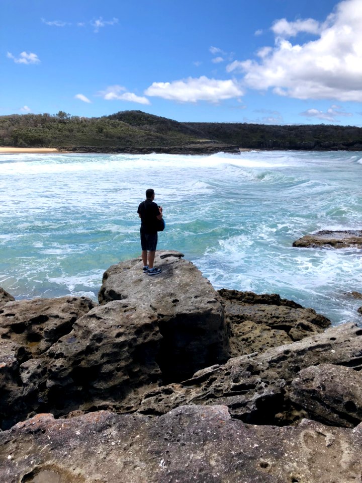 Photograph Of Person On Cliff Facing Island At A Distant