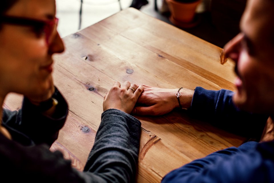 Man And Woman Sitting Together In Front Of Table