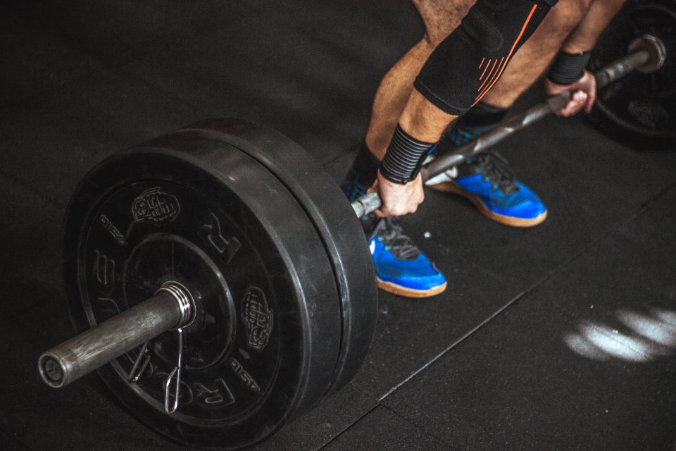 Close-up Of A Persons Lower Body Holding Barbell