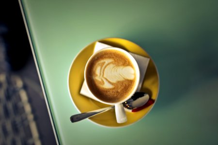 Coffee Latte On Saucer Beside Spoon photo