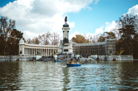 Boat In Water And Building With Statue photo