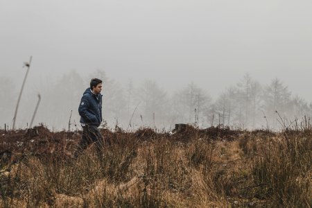 Man Walking On Grass Field