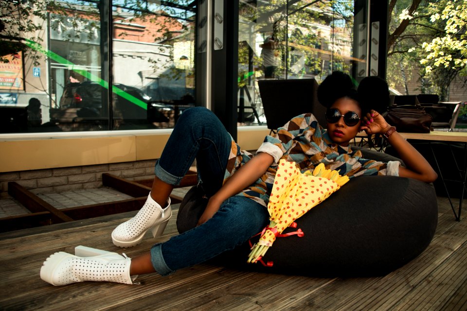 Woman Lying On Black Bean Bag Chair Near Cafe