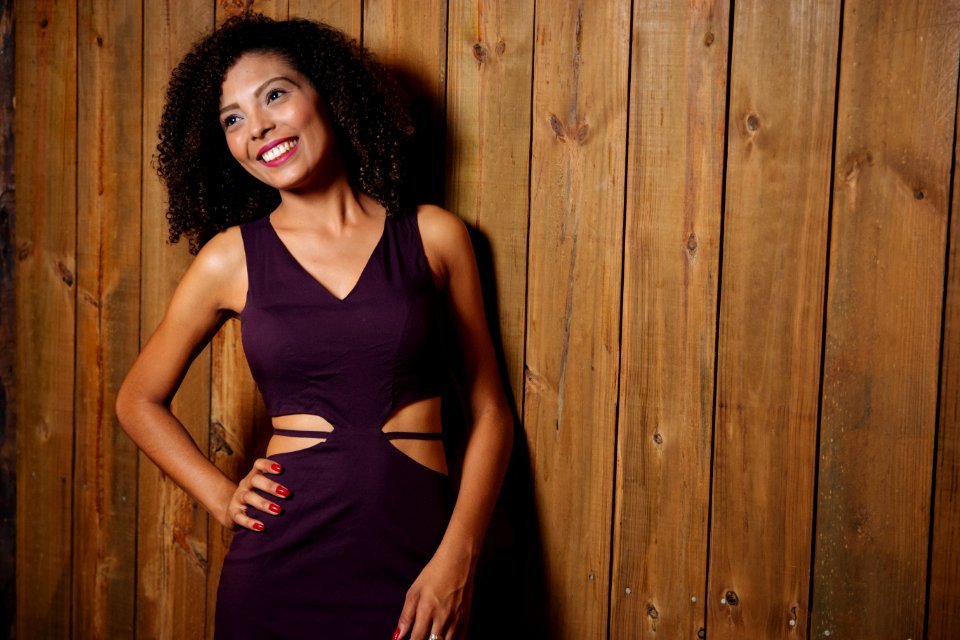Woman In Purple V-neck Cutout Dress Leaning On Brown Wooden Wall