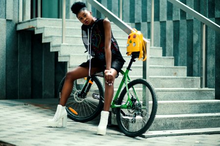 Woman In Black Sleeveless Dress Sitting On Green Bike photo