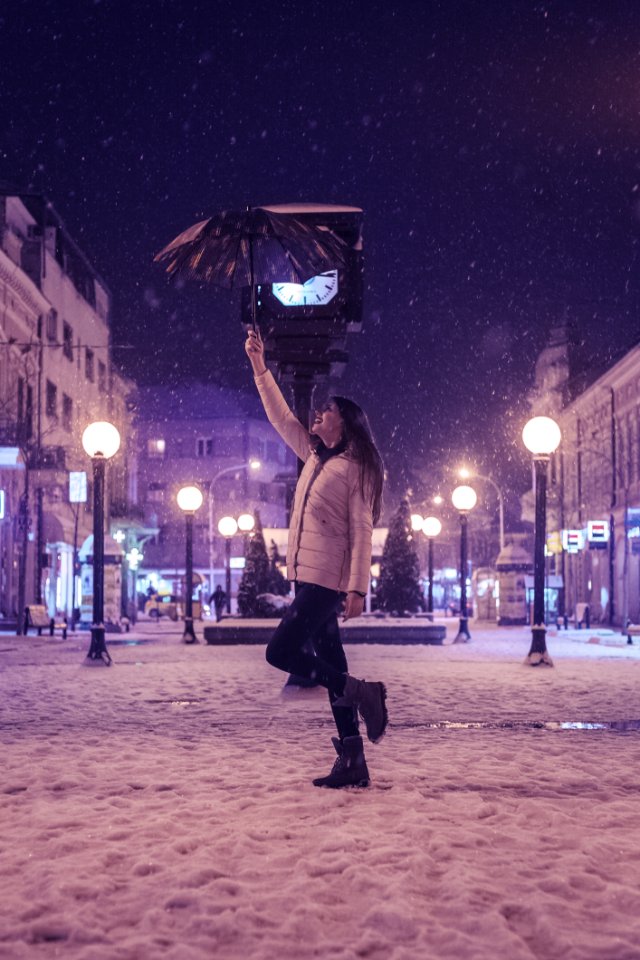 Woman In White Bubble Jacket And Black Jeans Standing While Holding Umbrella