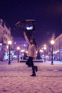 Woman In White Bubble Jacket And Black Jeans Standing While Holding Umbrella photo