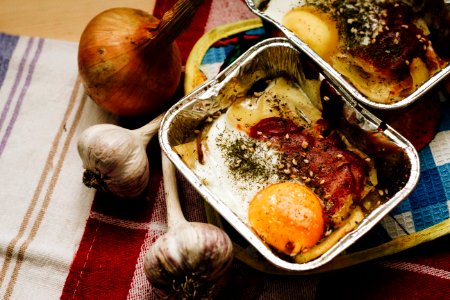 Cooked Food In Square Grey Tray Beside Garlics And Onion