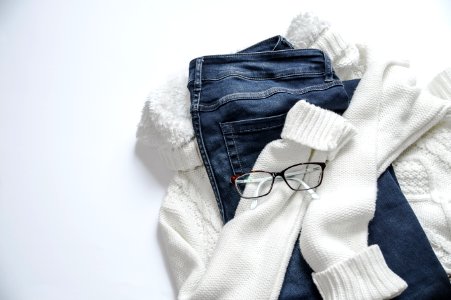 Black Framed Eyeglasses On White Jacket And Blue Denim Bottoms photo