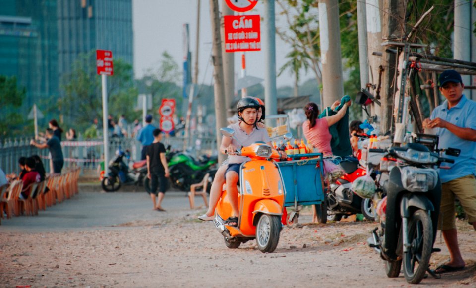 Man Wearing Grey Shirt Riding On Orange Motor Scooter At Daytime