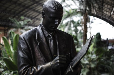 Man Wearing Blazer Holding Book And Pen Statue photo