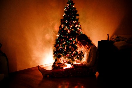 Photo Of Woman Sitting Near The Christmas Tree photo