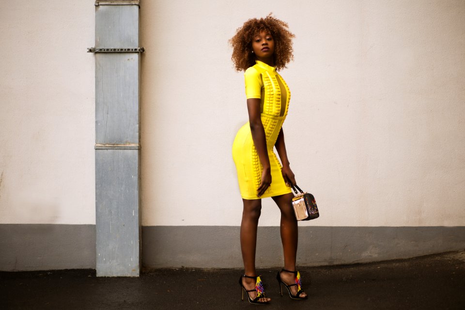 Woman In Yellow Knitted Dress Holding Beige Handbag