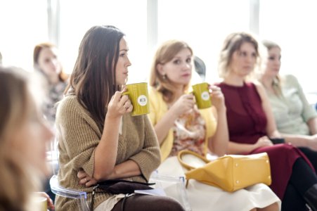 Woman Wearing Brown Corduroy Coat Holding Mug While Sitting On Chair photo