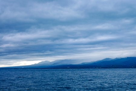 Island Across Body Of Water Under Cloudy Sky photo
