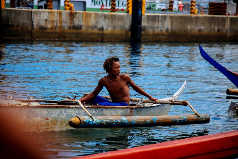 Man In Blue Shorts On Gray Boat photo