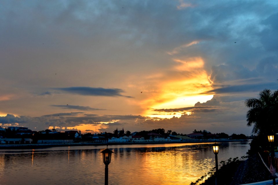 Lamppost Near Body Of Water At Golden Hour