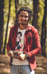 Man In Red Zip-up Hoodie Holding Pine Cone photo