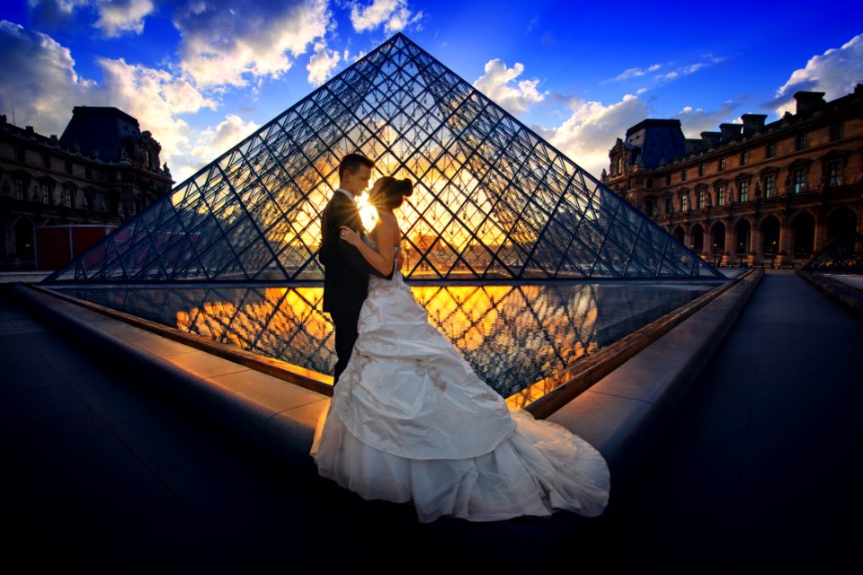 Photography Of Man And Woman At The Lourve Museum During Sunset