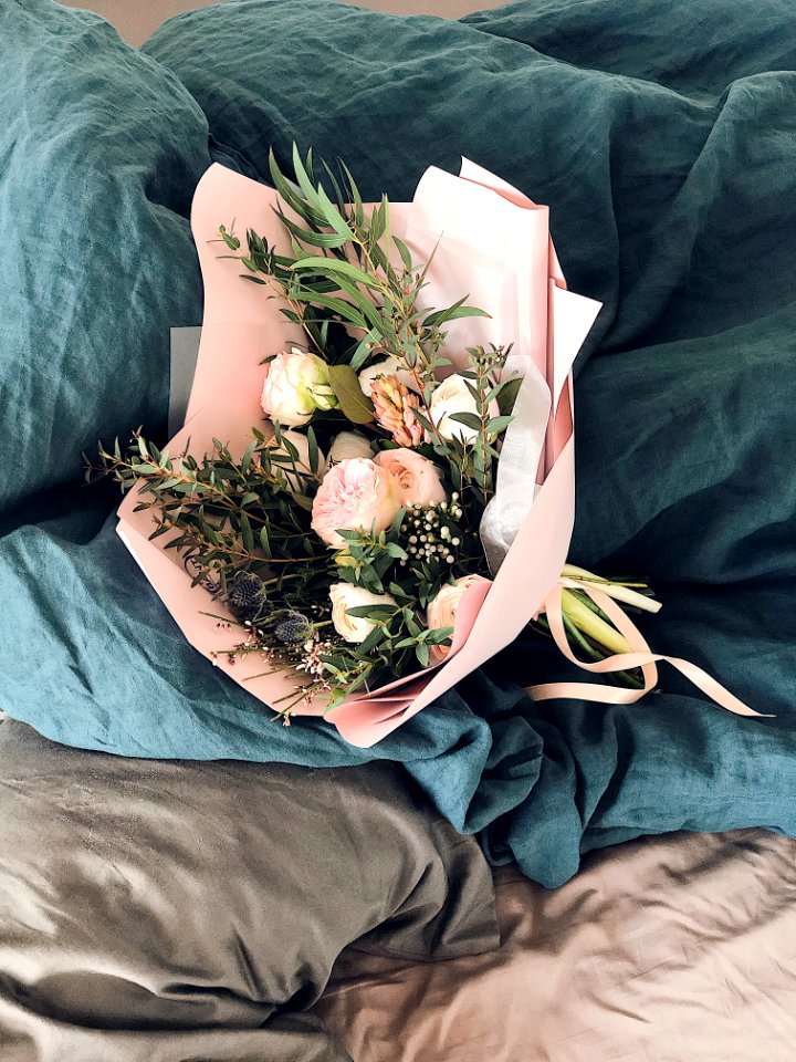 Pink And Green Flower Bouquet On Bed Sheet