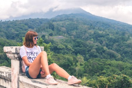 Woman In White Shirt And Blue Denim Short Shorts Sitting photo