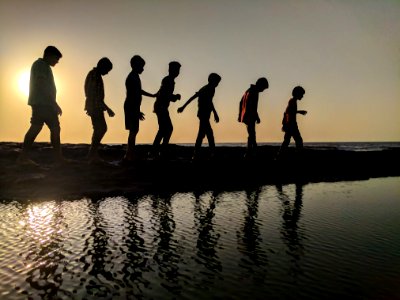 Group Of Children Walking Near Body Of Water Silhouette Photography photo