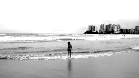 Grayscale Photo Of Female Standing Seashore photo