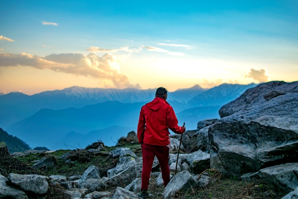 Man Wearing Red Hooded Jacket And Red Pants While Holding Black Metal Stick