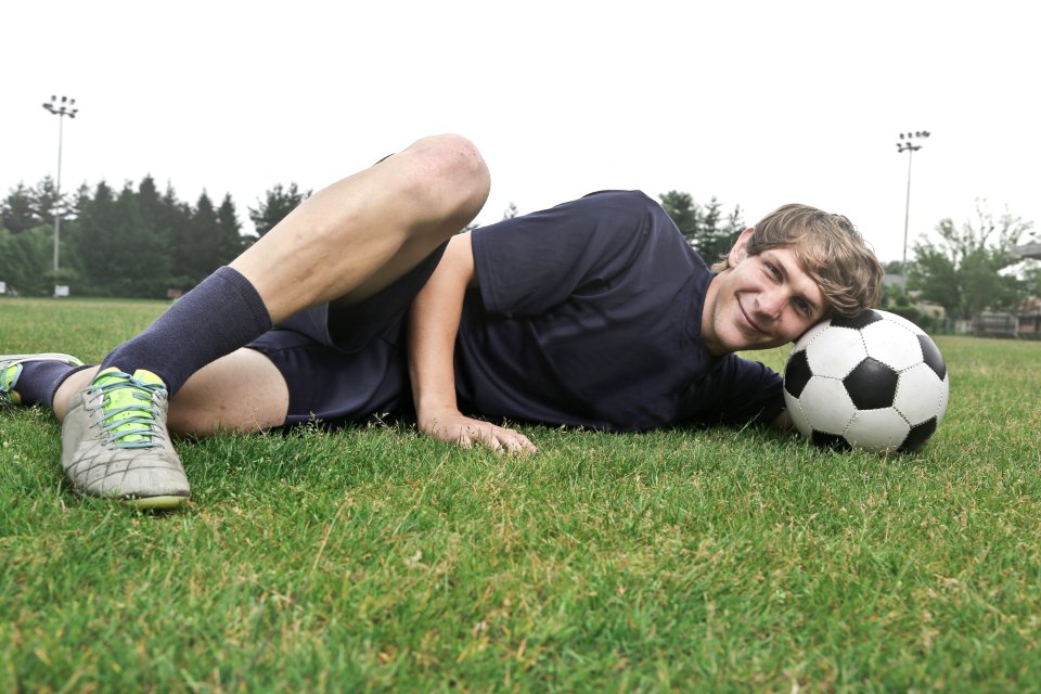 Man Wearing Black Crew-neck Shirt And Black Shorts Lying On Green Grass At Daytime