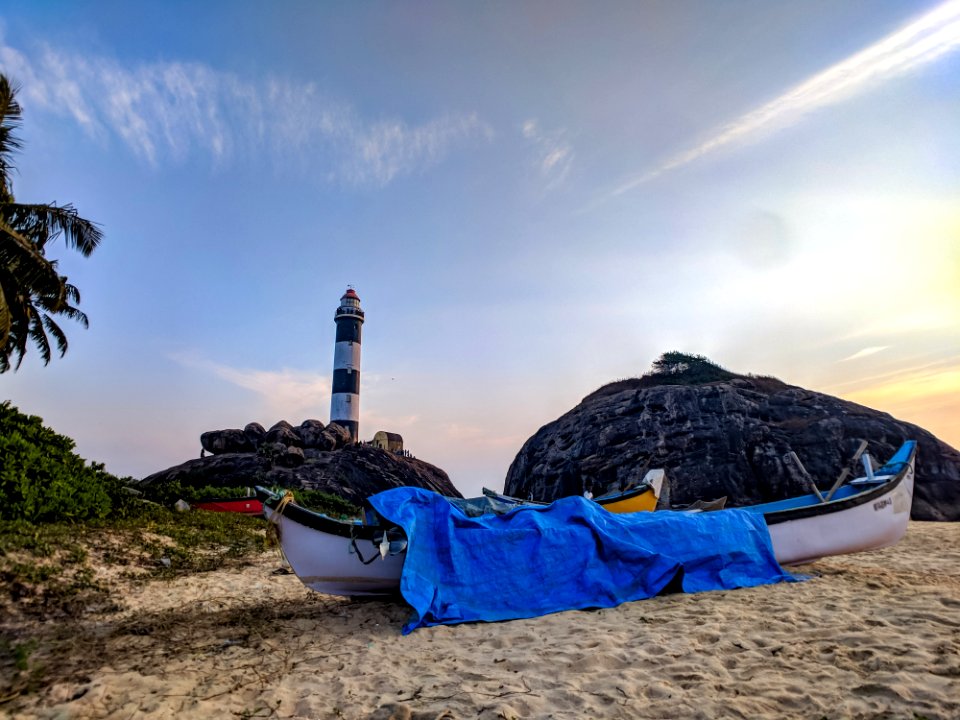White Canoe With Blue Cover On Sand