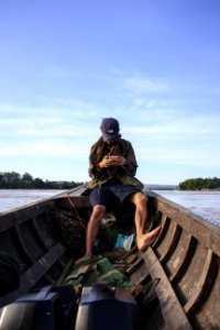 Man Wearing Black Cap Sitting Inside A Boat photo
