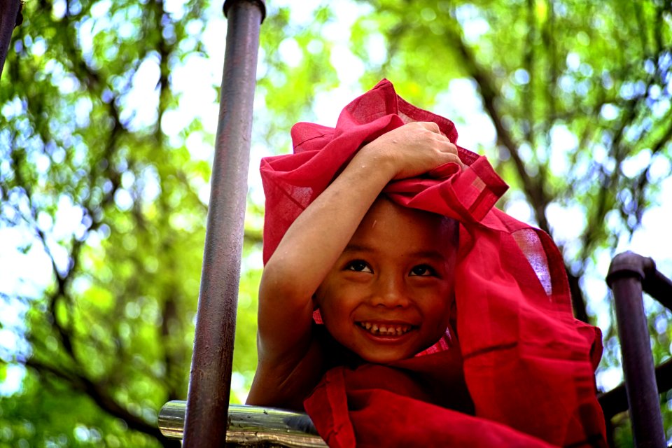 Boy Holding Red Textile Covering His Head