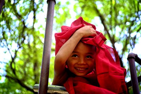 Boy Holding Red Textile Covering His Head