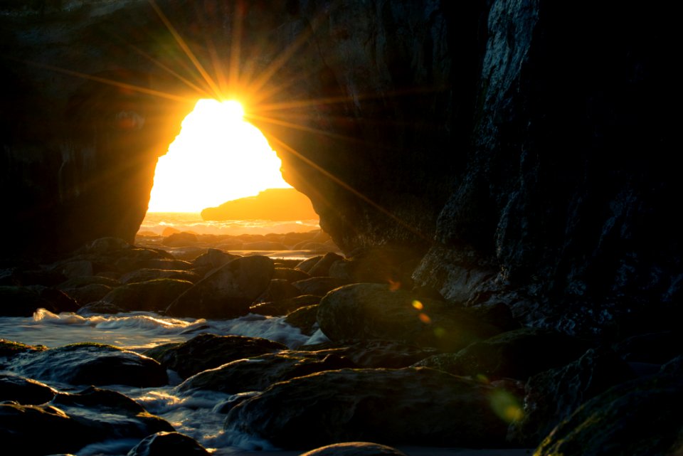 Cave Near Body Of Water At Sunset