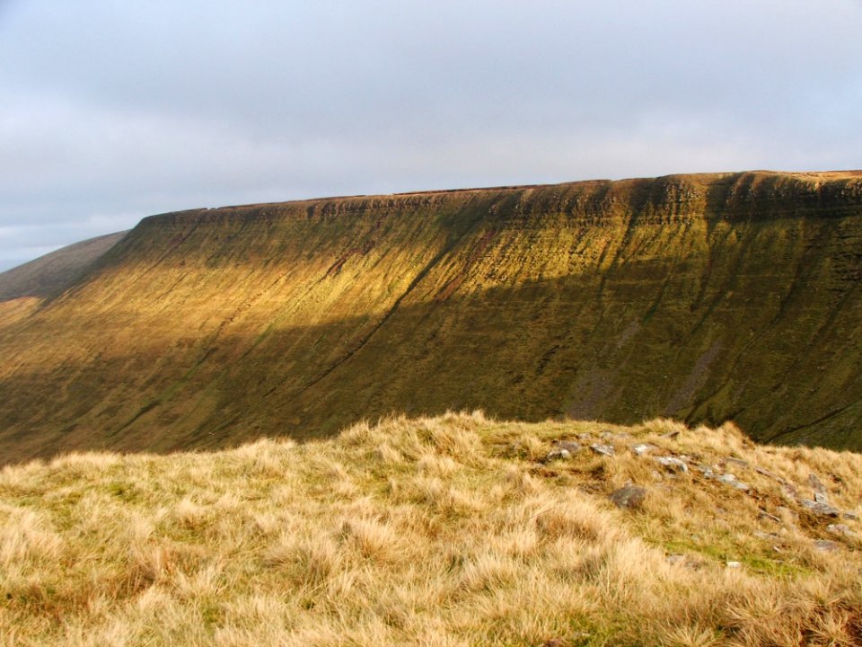 Photo Of Gray Grass Field Across Hill
