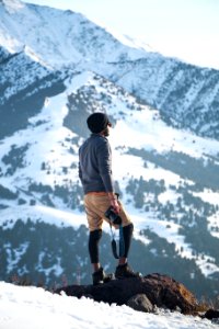 Man Wearing Gray Long-sleeved Shirt And Brown Shorts Holding Black Dslr Camera On Mountain photo