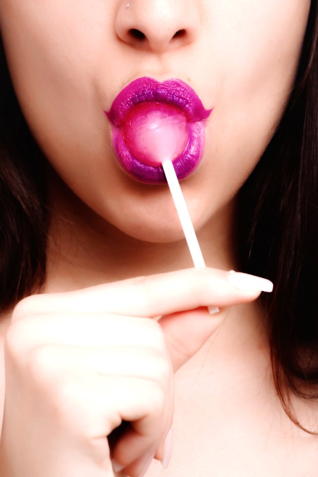 Woman With Pink Lipstick Licking Strawberry Lollipop