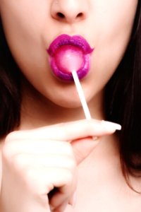 Woman With Pink Lipstick Licking Strawberry Lollipop