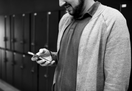 Grayscale Photo Of Man Wearing Zip-up Jacket Holding Android Smartphone photo