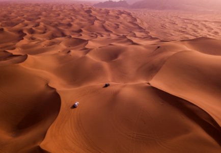 Two Vehicles On Desert Dunes