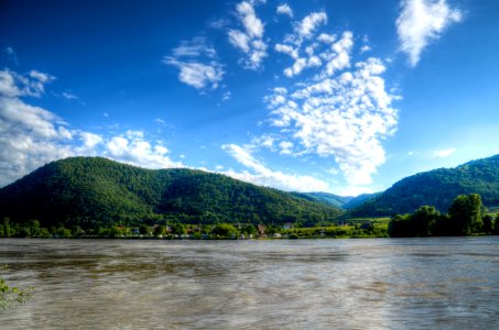 Body Of Water Near Mountains Under Blue Sky photo