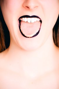 Woman Wearing Black Lipstick Tongue Out Photo photo