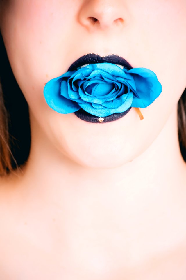 Woman Wearing Black Lipstick With Blue Rose On Mouth