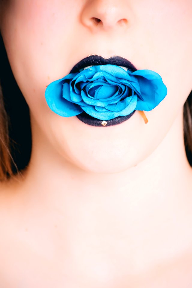 Woman Wearing Black Lipstick With Blue Rose On Mouth photo