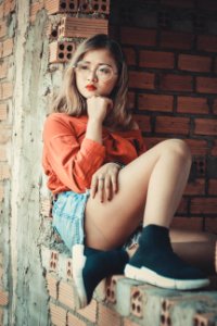 Woman Wearing Orange Scoop-neck Long-sleeved Top And Blue Denim Mini Shorts photo